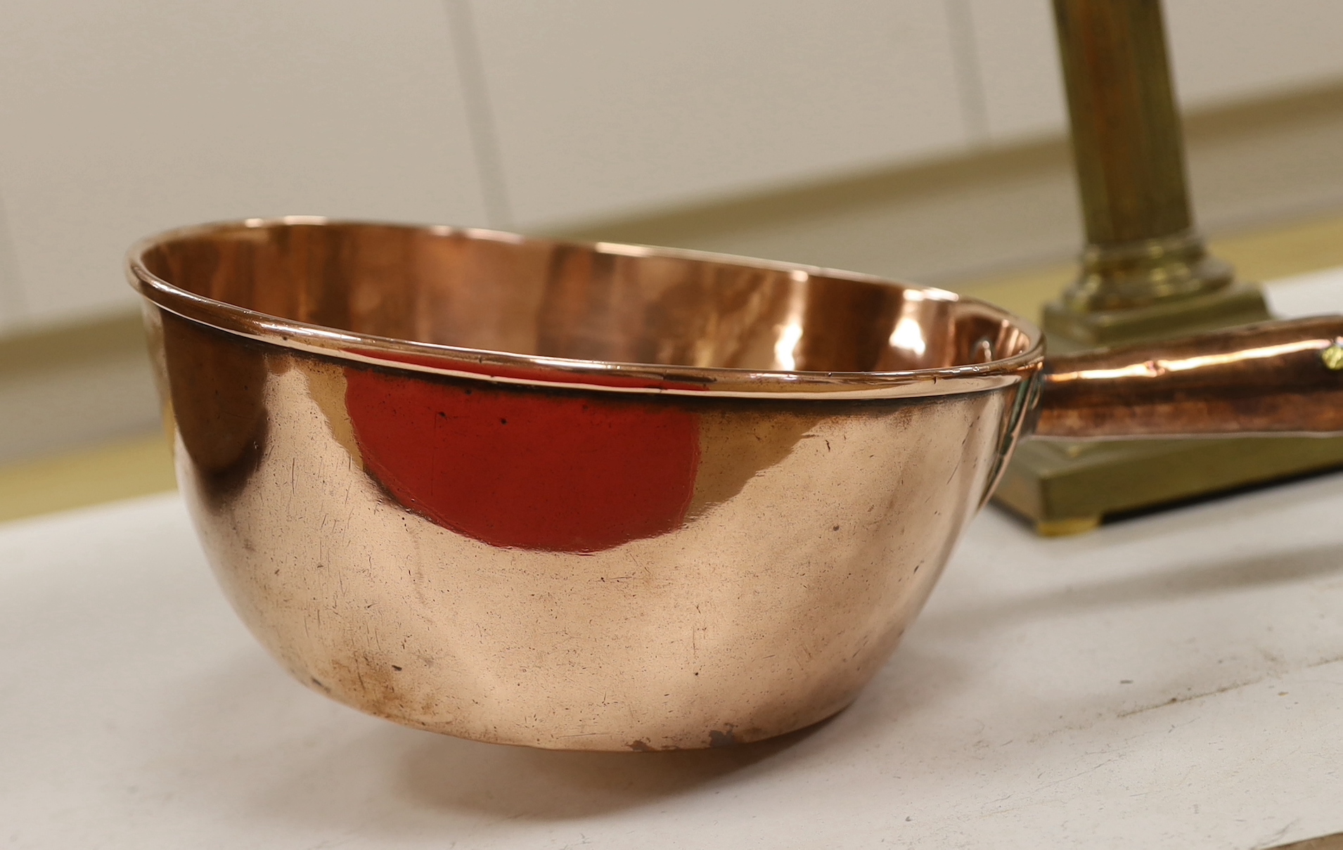 A brass Corinthian column oil lamp, two brass wall sconces and an 1823 copper saucepan